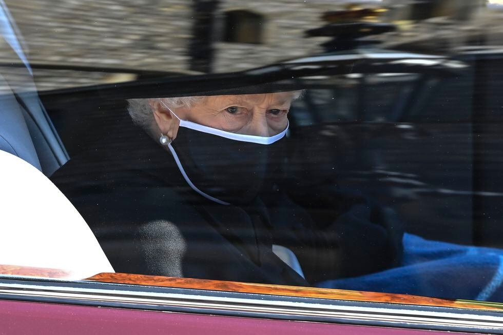 Britain's Queen Elizabeth II follows the coffin in a car as it makes its way past the Round...
