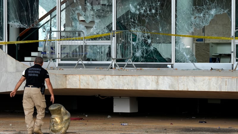 An agent walks past the head of a statue depicting the Greek goddess Themis, outside the...